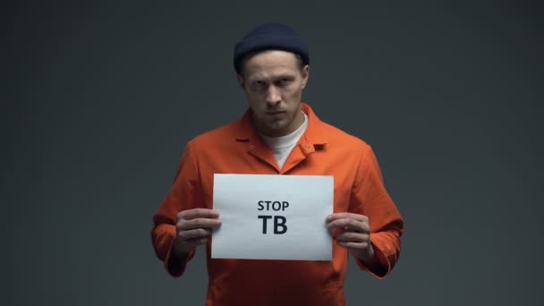 Hombre preso sosteniendo señal Stop TB, atención médica en prisión, condiciones de vida — Vídeo de stock