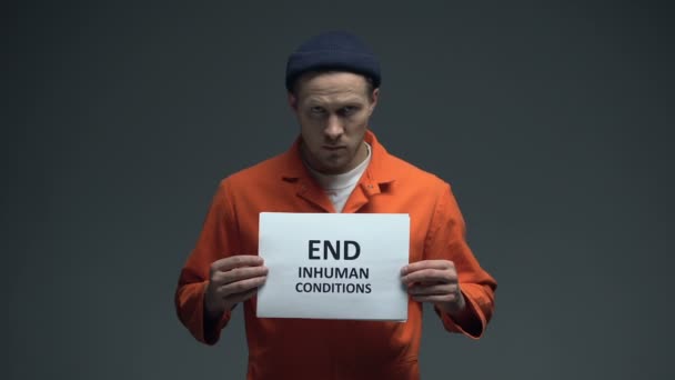 Prisioneiro que detém Fim de condições desumanas sinal na cela, proteção de direitos humanos — Vídeo de Stock