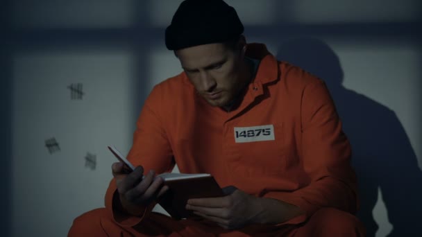 Imprisoned male reading book in jail cell, available hobby, self-education — Stock Video