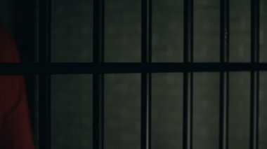 Hapisteki adam, barların yakınında ayakta duran yaralar, kavgadan sonra hapsedilme