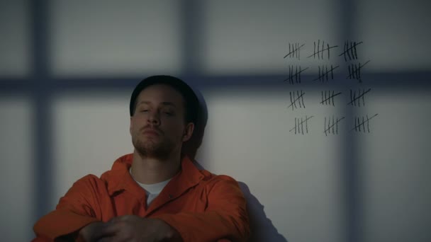 Mężczyzna więzień patrząc na skrzyżowane linie na ścianie komórkowej, służąc długie więzienie — Wideo stockowe