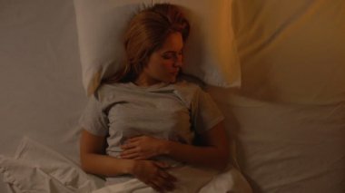 Çekici bayan esneme ve yatakta germe, gülümseme ile yeni bir gün tebrik