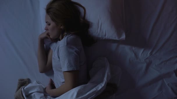 Mujer despertando debido a un espasmo en el estómago y tomando analgésicos, vista superior — Vídeos de Stock