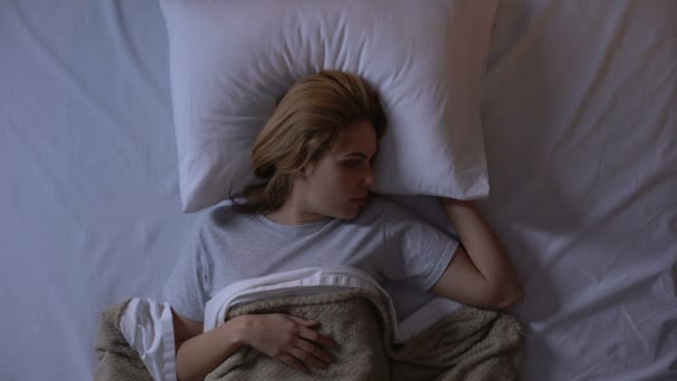 Menina irritada fechando ouvidos com travesseiro, vizinhos barulhentos perturbando o sono à noite — Vídeo de Stock