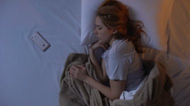 Yorgun bayan enerji akıllı telefon eksikliği, uykulu ruh üzerinde çalar saat kapatarak