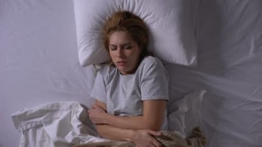 Genç bir kadın ateşler içinde yanıyor, kemikleri sızlıyor, virüse yakalanıyor ve yatakta yatıyor.