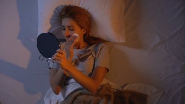 Güzel bayan uyumadan önce makyaj çıkarmadan, cilt bakım ürünleri, üst görünümü