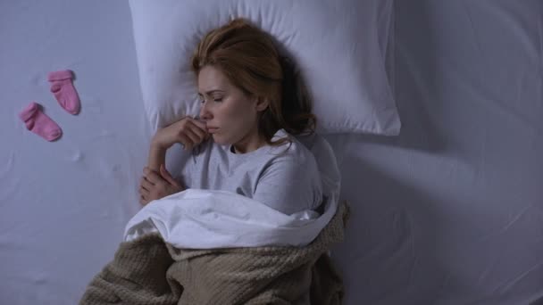 Senhora chorando escondendo meias de bebê sob travesseiro, aborto espontâneo, infertilidade — Vídeo de Stock