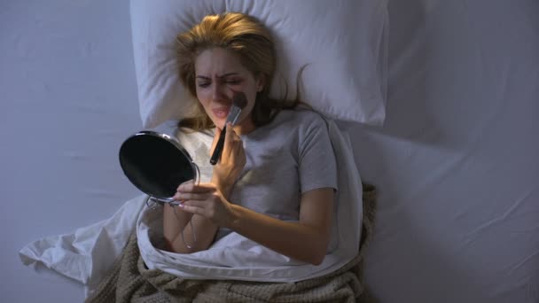 Víctima femenina tratando de cubrir la herida en la cara con polvo, llorando desesperanza — Vídeos de Stock