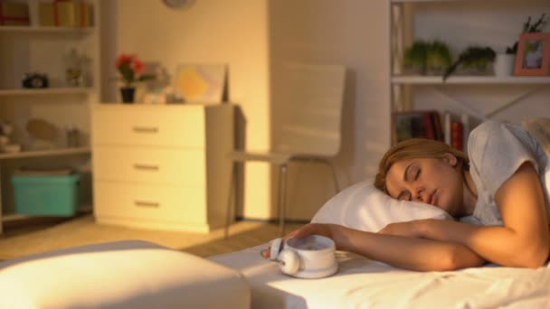 Fiatal nő óra a kézben felugrik az ágyból, későn kel fel a munkából, elalszik — Stock videók