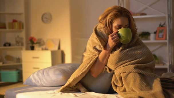 Enferma mujer cubierta manta beber té caliente sentado en la cama, cuidado de la salud, virus — Vídeos de Stock