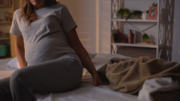 妊娠中の女性はベッドに横たわって、日没、夜のルーチン、レクリエーションで眠りに落ちる — ストック動画