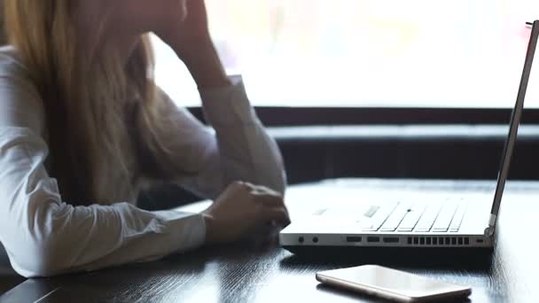 Женщина, работающая над ноутбуком и нервно сжимающая кулаки, беспокоясь о проекте — стоковое видео