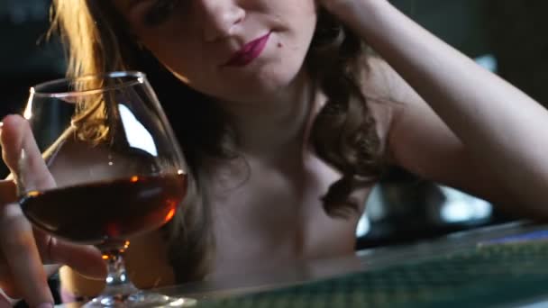 Deprimida dama sentada sola en el bar, mirando un vaso de brandy, romper — Vídeos de Stock
