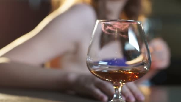 Пьяная женщина флиртует в клубе, стакан бренди на барной стойке, алкогольное воздействие — стоковое видео