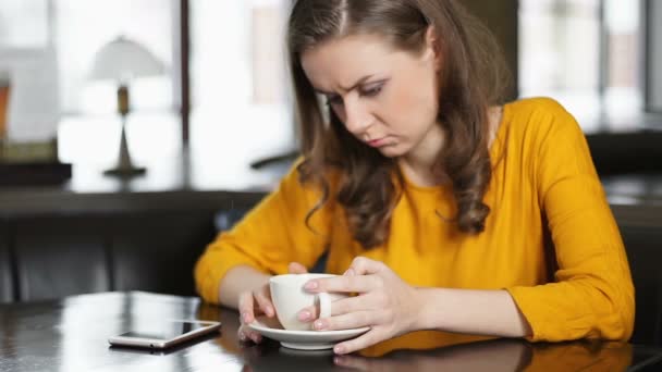 Mujer molesta sentada en la cafetería, comprobando el teléfono inteligente, esperando la llamada de su amada — Vídeo de stock