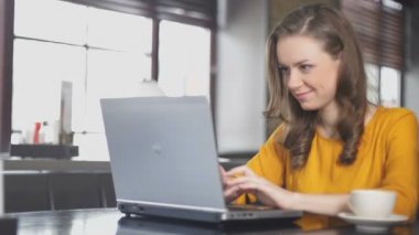 Kafede dizüstü bilgisayar kullanan heyecanlı kadın, online piyango kazanan, zafer dansı