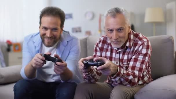 Dos hombres adultos ganando videojuegos dando choca esos cinco, celebrando la victoria, el ocio — Vídeo de stock