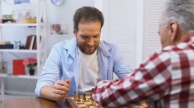 Satranç oynayan yetişkin erkekler, baba ve oğul rekabet, hobi ve eğlence aktivitesi
