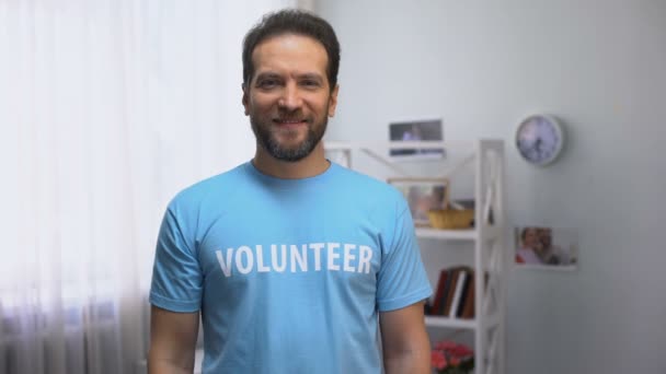 Muž středního věku, dobrovolník, který se dívá na kameru, dobročinnou organizaci, — Stock video