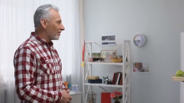 Middle aged volunteer bringing senior man tray with breakfast, looking to camera — Stock Video