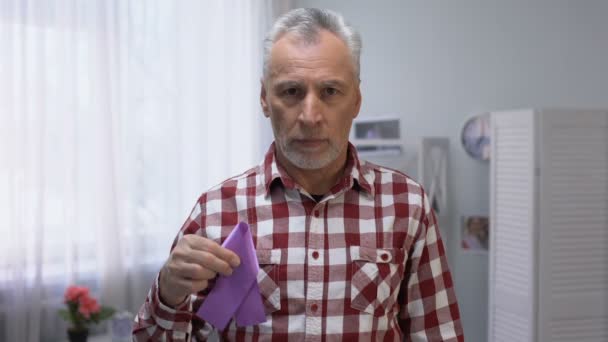 Старший мужчина показывает фиолетовую ленту к камере, болезнь Альцгеймера осведомленность, уход — стоковое видео