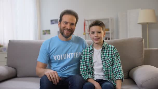 Sonriente voluntario de mediana edad y colegial empujando pulgares hacia arriba a la cámara, anuncio — Vídeos de Stock