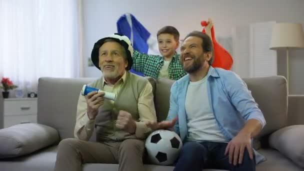 Emocionado miembros de la familia masculina animando por el campeonato del equipo de fútbol francés en casa — Vídeos de Stock