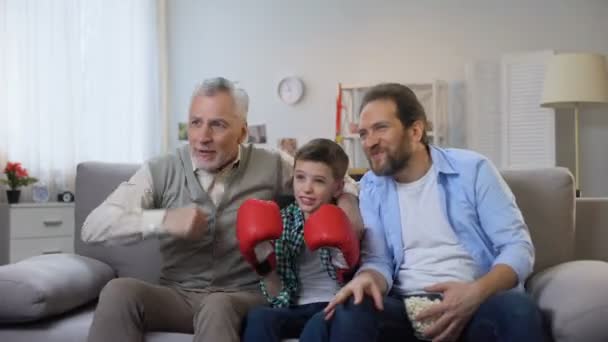 兴奋的多年龄家庭成员欢呼最喜欢的拳击手在电视上观看比赛 — 图库视频影像