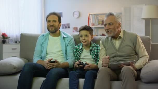 Opa und Papa jubeln dem Jungen zu, der Videospiel, Hobby und Freizeitaktivität spielt — Stockvideo