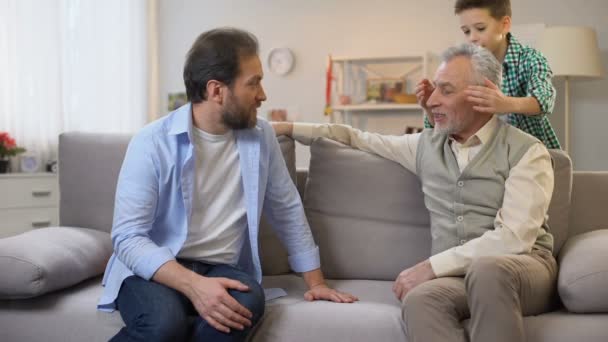 Vater und Sohn machen Geburtstagsüberraschung für Senioren-Opa und schenken Geschenkbox — Stockvideo