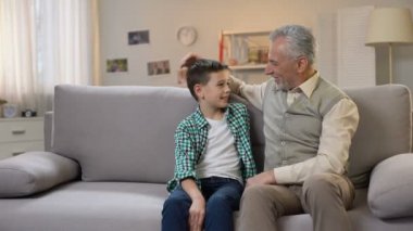 Kıdemli erkek ve preteen çocuk gülümseyen ve kamera, geç çocuk istatistikleri arıyor