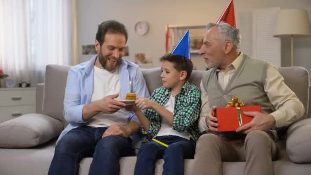 Стареющий мужчина и школьник поздравляют мужчину средних лет с подарочной коробкой и тортом — стоковое видео