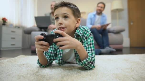 Мальчик-подросток, играющий в видеоигры, папа и дедушка улыбаются, отдыхают и увлекаются — стоковое видео