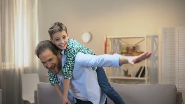 Веселые папа и сын играют в самолет, счастливые семейные моменты, детство — стоковое видео