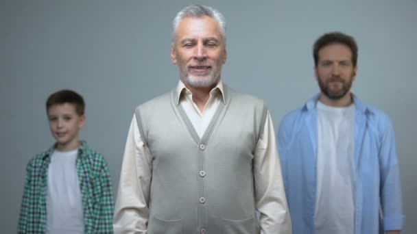 Hombre mayor, hombre de mediana edad y niño pequeño mirando a la cámara, generaciones — Vídeos de Stock