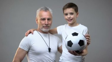 Kıdemli futbol antrenörü gülümseyen sarılma genç çocuk, aktif sağlıklı yaşam tarzı, spor