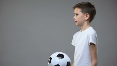 Okul çocuğu futbol topu ile oynuyor ve kamera, aktif eğlence hobi arıyorum