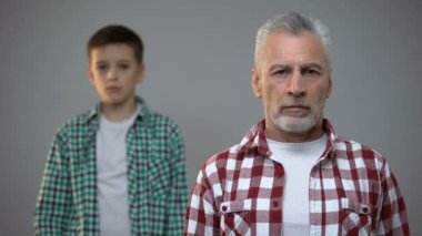 Kameraya bakan yaşlı erkek, arkada duran küçük çocuk, emeklilik yaşı artışı
