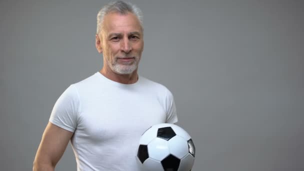 Homme athlétique âgé jouant avec le ballon de football, entraîneur de football, mode de vie actif — Video