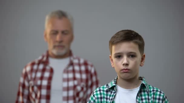 Adolescente serio mirando a la cámara, hombre de edad detrás, conexión con los antepasados — Vídeos de Stock