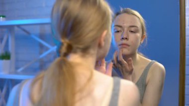 Sorunu örten genç bir kadın cildini kapatıcı ve dermatoloji tedavisiyle gizliyor.