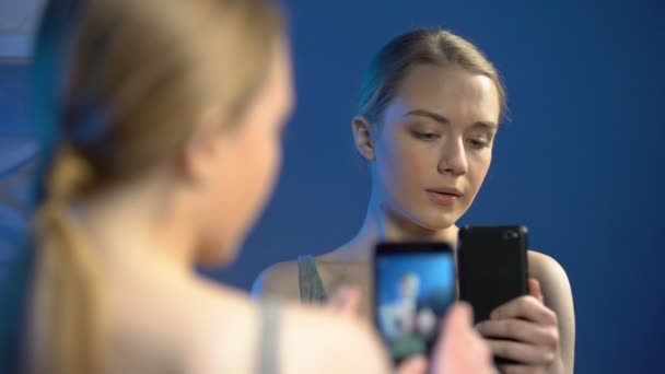 Женщина-подросток делает селфи перед зеркалом на смартфоне, блоггер красоты — стоковое видео