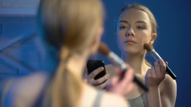 Mladá žena dělá make-up sledování online videa na smartphonu, tipy krásy — Stock video