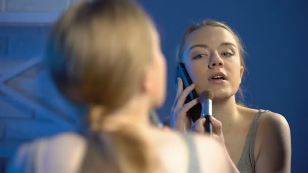 Upptagen ung kvinna tillämpa pulver talande telefon frontspegel, förberedelser för datum — Stockvideo