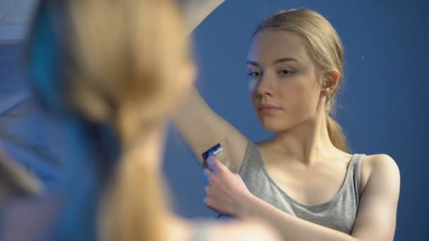 Гарненька підліток голиться пахви перед ванною дзеркало, догляд за тілом, гігієна — стокове відео