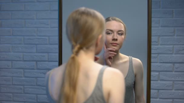 Jonge vrouw kijken spiegel reflectie en glimlachen in de camera, natuurlijke schoonheid — Stockvideo