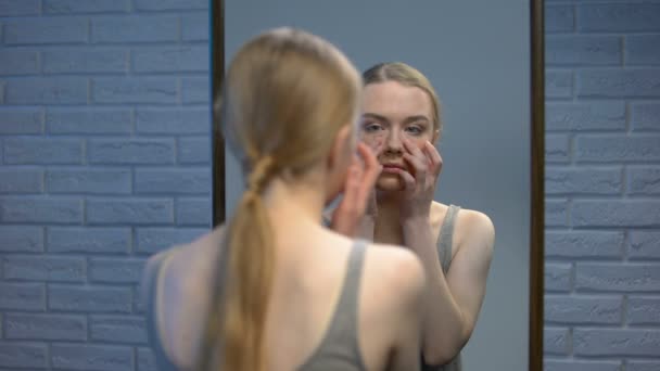 Ongelukkige tiener onderzoekt gezicht huid spiegel, op zoek helaas camera, onvolmaaktheid — Stockvideo