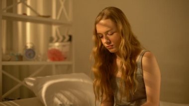 Kız öğrenci hamilelik testi sonucu, kontrasepsiyon bakarak rahat lık la iç çekiyor