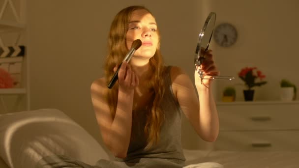 Счастливая молодая женщина наносит макияж румяна улыбаясь на камеру, природная красота — стоковое видео